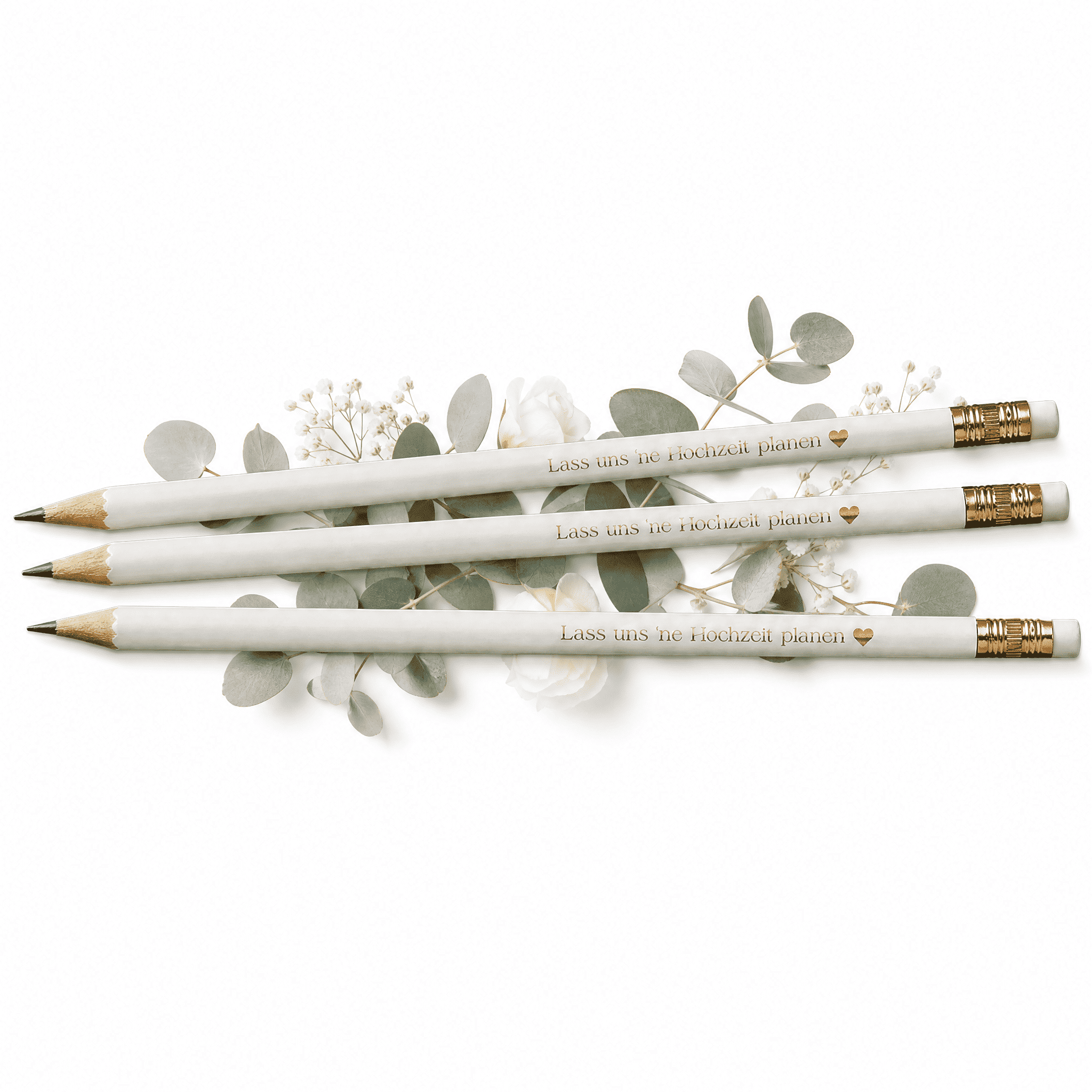 Drei weiße Bleistifte mit goldenem Radiergummikopf und dem Text "Lass uns 'ne Hochzeit planen" von Mein kleines Hochzeitsbüro liegen auf Eukalyptusblättern - das perfekte Bleistift-Set für deine Hochzeitsplanung.