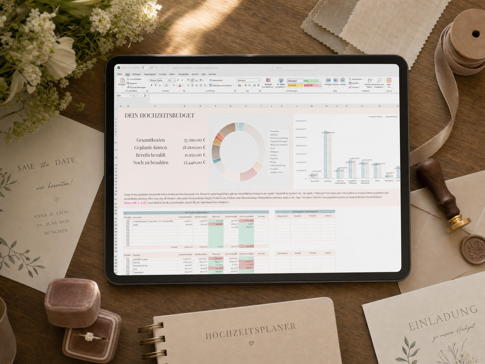 Auf einem Tablett wird eine Tabelle mit Diagrammen und Tabellen für das Hochzeitsbudget angezeigt, umgeben von Hochzeitseinladungen, Briefpapier, Ringen in einer Schachtel, Blumen und einem Stift auf einer Holzoberfläche.