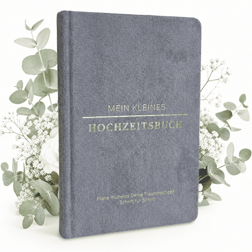 Das "Mein kleines Hochzeitsbuch - Eleganter Nebel" von Mein kleines Hochzeitsbüro mit goldener Schrift steht zwischen weißen Blumen auf weißem Hintergrund - der perfekte Start für eure Hochzeitsplanung.