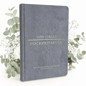 Das "Mein kleines Hochzeitsbuch - Eleganter Nebel" von Mein kleines Hochzeitsbüro mit goldener Schrift steht zwischen weißen Blumen auf weißem Hintergrund - der perfekte Start für eure Hochzeitsplanung.