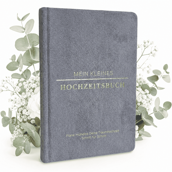 Das "Mein kleines Hochzeitsbuch - Eleganter Nebel" von Mein kleines Hochzeitsbüro mit goldener Schrift steht zwischen weißen Blumen auf weißem Hintergrund - der perfekte Start für eure Hochzeitsplanung.