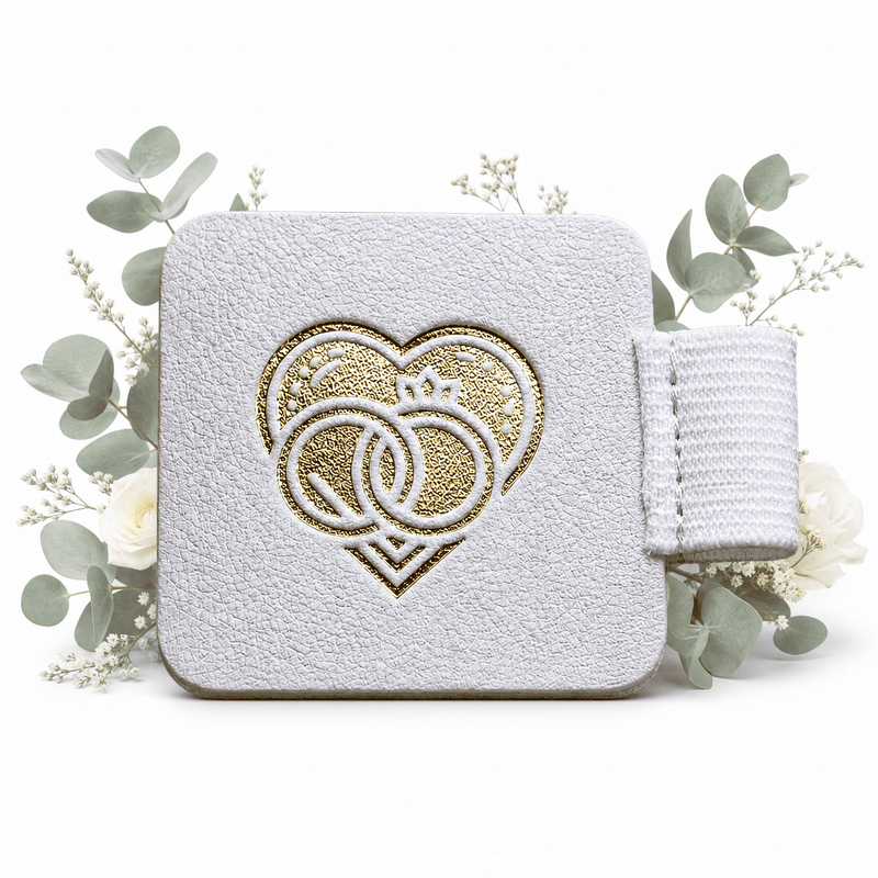 Der Stiftehalter - Schlaufe Standard von Mein kleines Hochzeitsbüro ist ein stilvoller Helfer für Hochzeitsplaner: Weiß, texturiert, mit goldener Prägung und ideal zur Aufbewahrung von Stiften, umgeben von Eukalyptus und weißen Blumen.