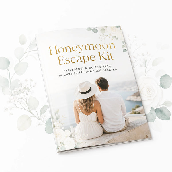 Das „Honeymoon Escape Kit“ von „Mein kleines Hochzeitsbüro“ enthält ein romantisches Heft mit Blumenmotiven, auf dessen Titelseite ein Paar am Wasser abgebildet ist, sowie Tipps zur Planung und eine Packliste für stressfreie, romantische Flitterwochen.