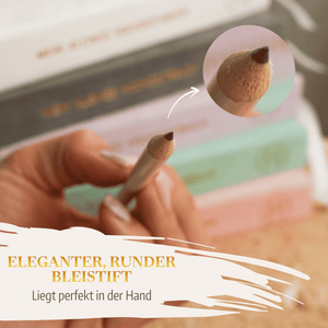 Eine Hand hält einen Bleistift aus dem "Bleistift-Set - Lass uns 'ne Hochzeit planen" von Mein kleines Hochzeitsbüro. Im Hintergrund liegen pastellfarbene Bücher - perfekt für die kreative Hochzeitsplanung.